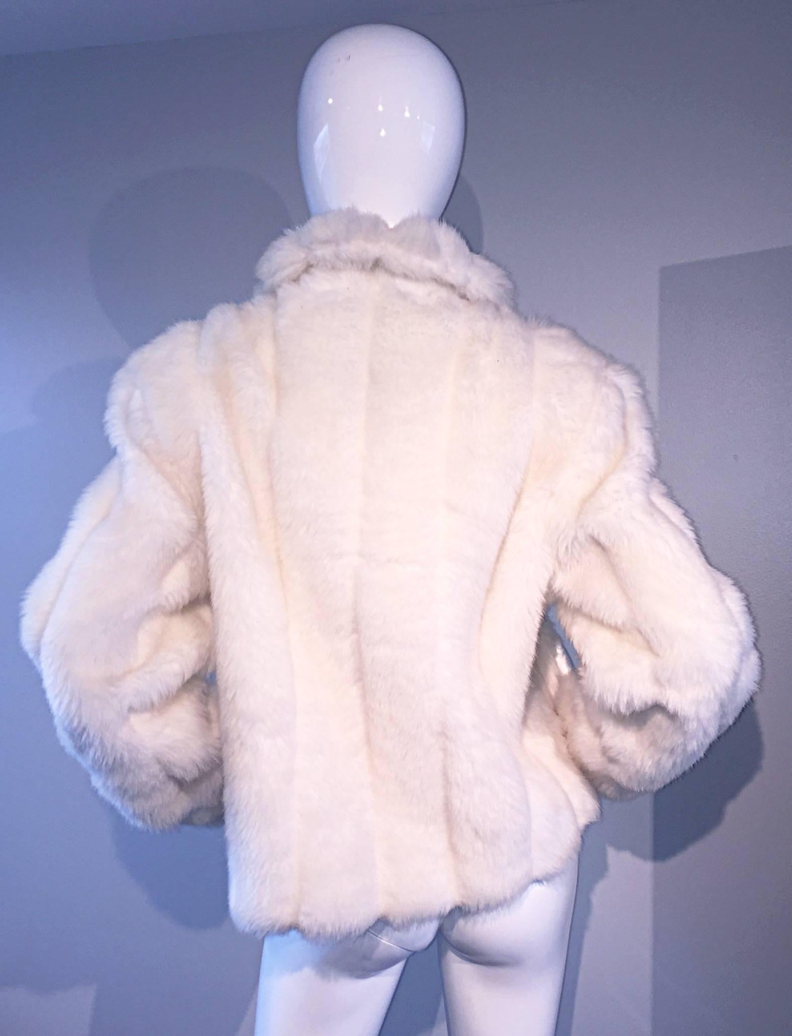 Amazing vintage OLEG CASSINI faux fur white jacket! So much style is exuded from this lovely coat! Zips up the bodice, with pom poms at both sides of the collar. Features pockets at both sides of the waist. Extremely comfortable, and keeps you very
