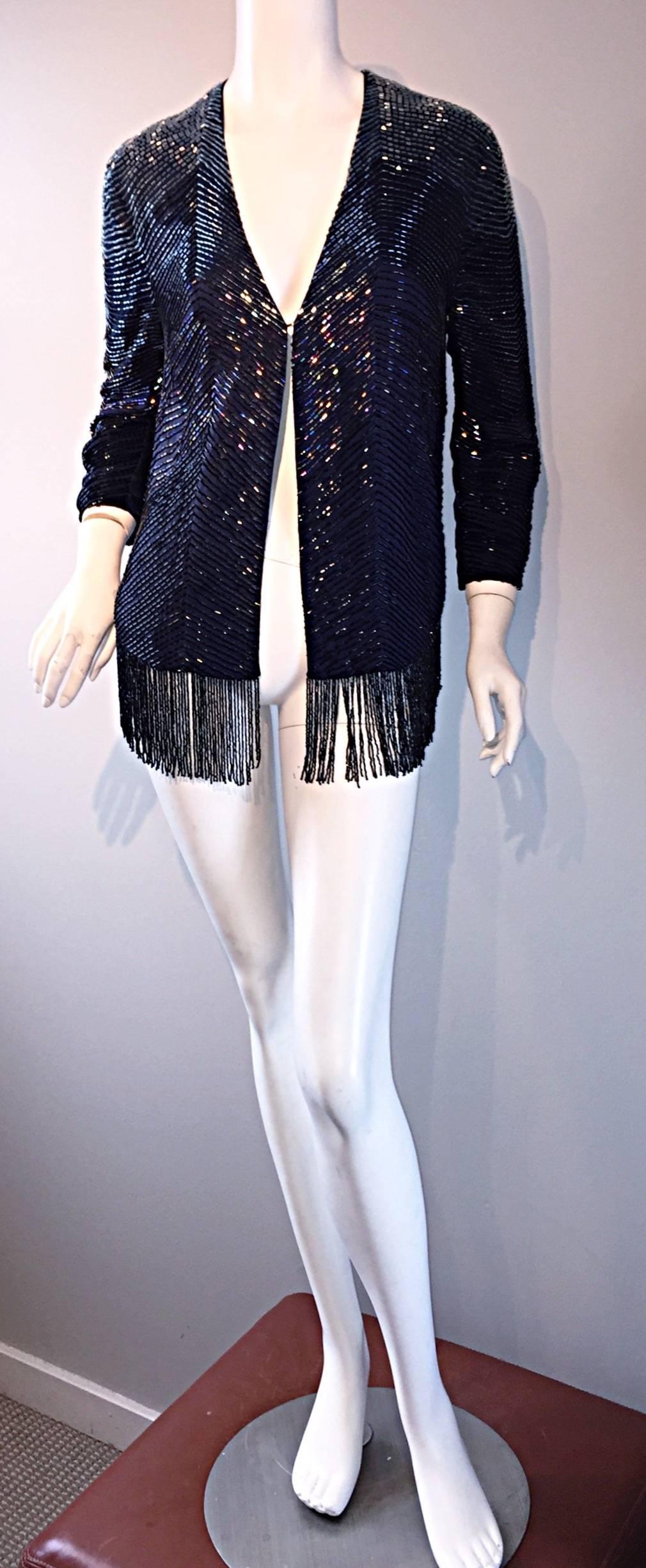 Beautiful vintage navy blue silk glass beaded cardigan! This beauty features all over hand-sewn glass beads, with beaded fringe on the entire hem. The perfect piece to add onto any outfit...gives the perfect finishing touch! Features a single