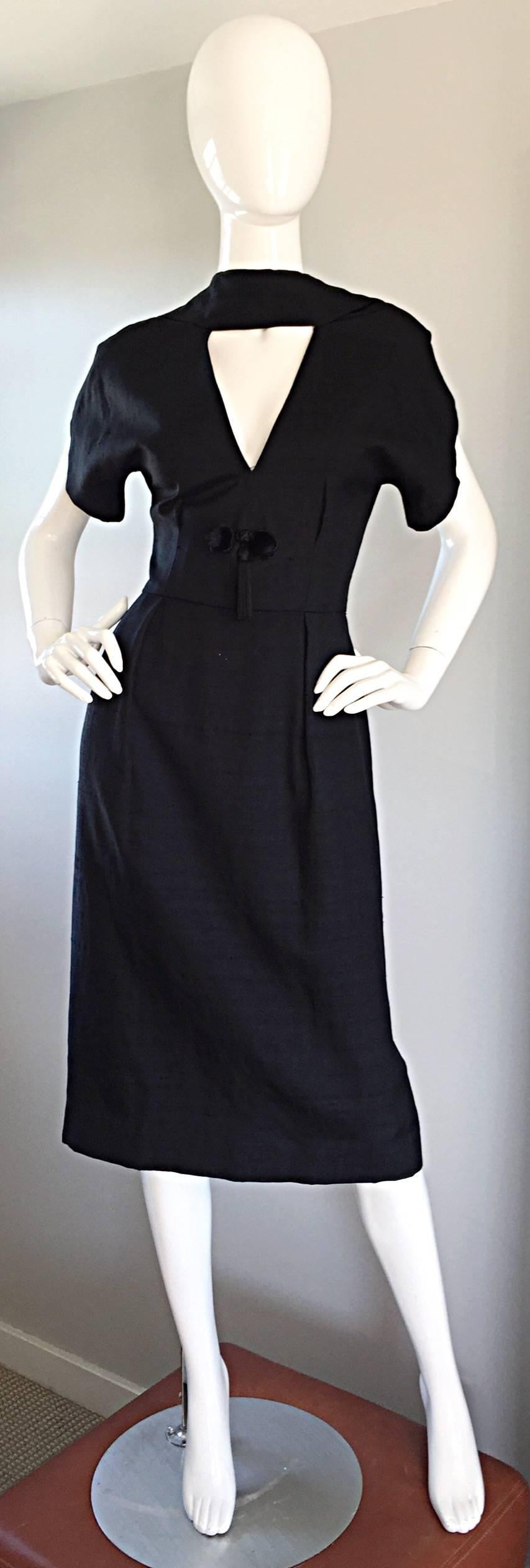 Extraordinary vintage 50s ESTEVEZ black silk dress! The detailing on this beauty is breathtakingly unbelievable! Features cut-out at bust, with dolman 40s style sleeves. Two mink fur pom poms adorn the waist, along with a black tassel. Amazing
