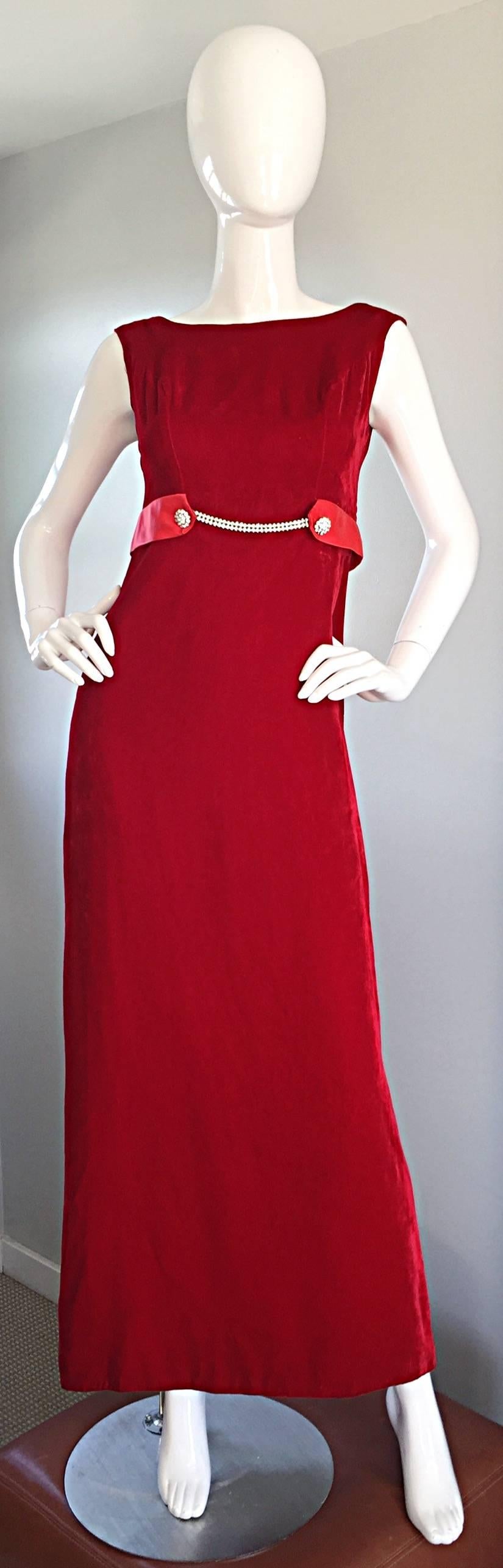Beautiful 1960s red velvet dress! Wonderful flattering fit, with a timeless style. Two mock rhinestones at either side of the waist, connected to a rhinestone chain in center. Soft, luxurious velvet. Chic bow attached at the back. A true head