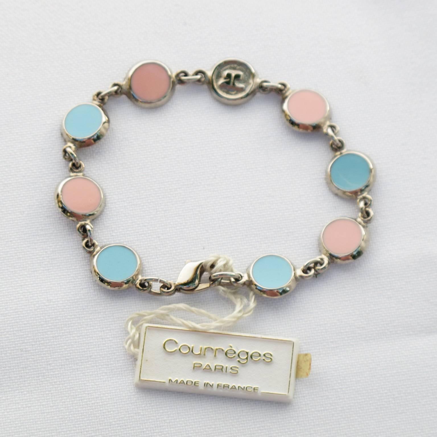 Courreges Paris signed link bracelet. Rare elegant 1970s Space Age silvered metal chain bracelet with coin shape ornate with enameling in pastel tones of pink and blue and topped with 