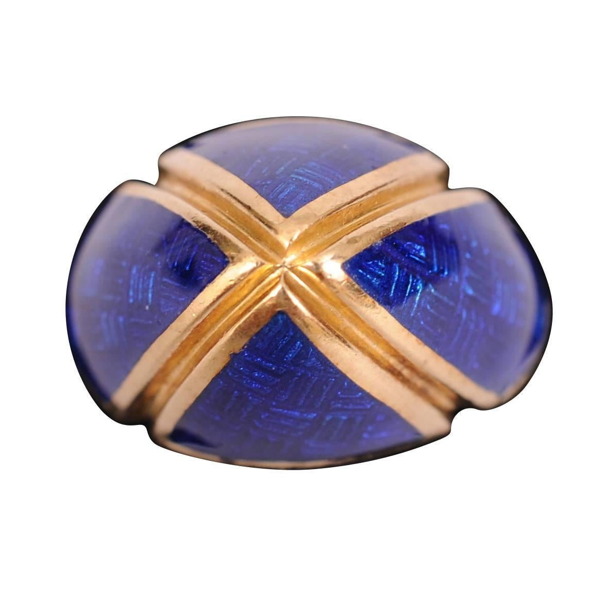 This 18 karat gold ring has four sections of blue enamel separated by gold bands. It is stamped 18k and signed with the makers initials. It is in excellent condition and measures a size 7.