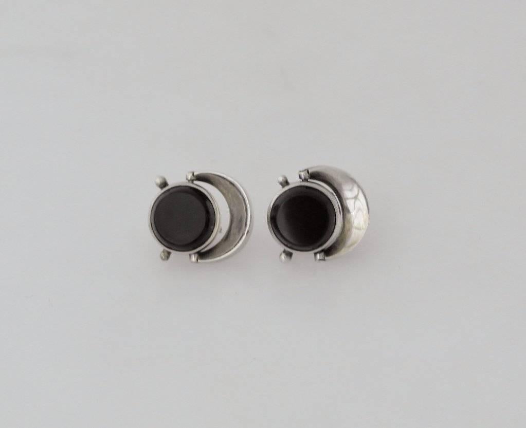 Being offered is a circa 1958 pair of sterling silver and onyx clip on earrings by Antonio Pineda of Taxco, Mexico, of modernist design.  Measure 3/4" wide.  Marked.  In excellent condition.

If you do not have the catalog 'Silver Seduction -