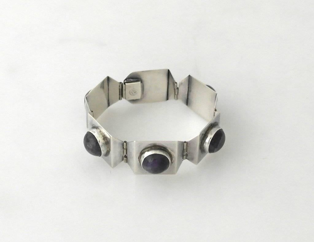 Being offered is a sterling silver and amethyst bracelet, by Taller Far Fan, of Taxco, Mexico, in a modernist design with square shaped silver links with beveled edges, each link with a large, vivid deep purpose stone.  The bracelet measures 7"