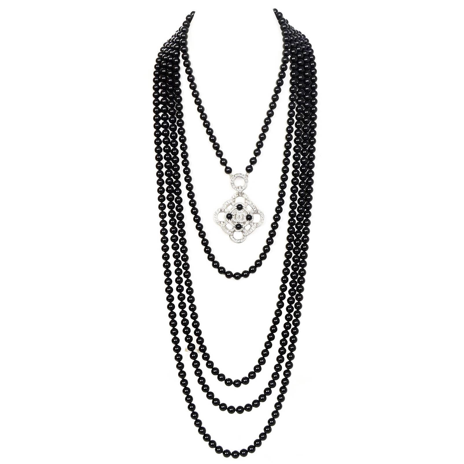 100% Authetic Chanel 2016 Black Beaded Necklace.  Features 5 strands of black glass beads at different lengths complimented by a clear crystal camelia pendant with black bead detail and CC logo.

Made In: Italy
Year of Production: 2016
Color: