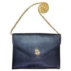 Vintage Christian Dior black leather chain clutch bag with golden logo motif.