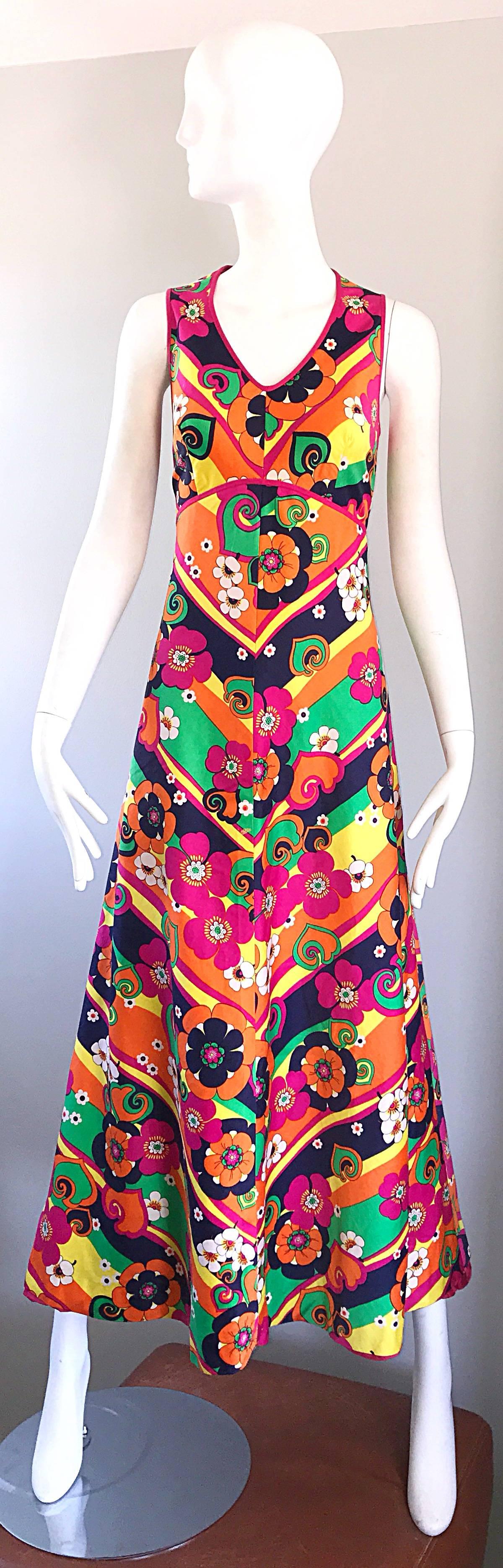 Amazing 1970s colorful cotton maxi dress! Features vibrant colors of pink, green, yellow, orange, white navy blue in flowers and stretch. Fitted bodice with a full body. Fully lined in pink. Very well made, with lots of attention to detail. Hidden