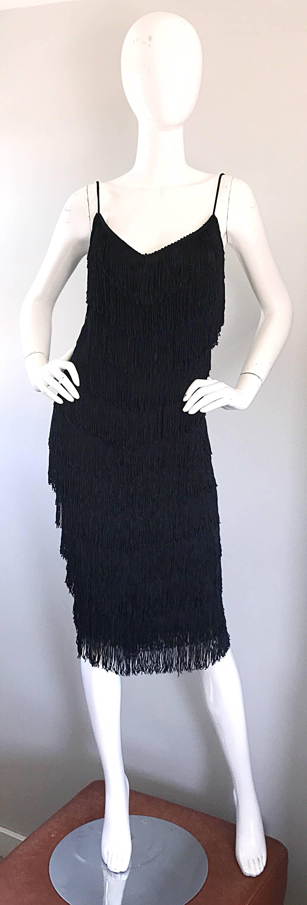 Spectacular 1970s JOY STEVENS black fully fringe sleeveless flapper dress! This statement maker features multiple tiers of fringe throughout the entire front, back and sides of the dress. Comftorable jersey material stretches to fit. Looks