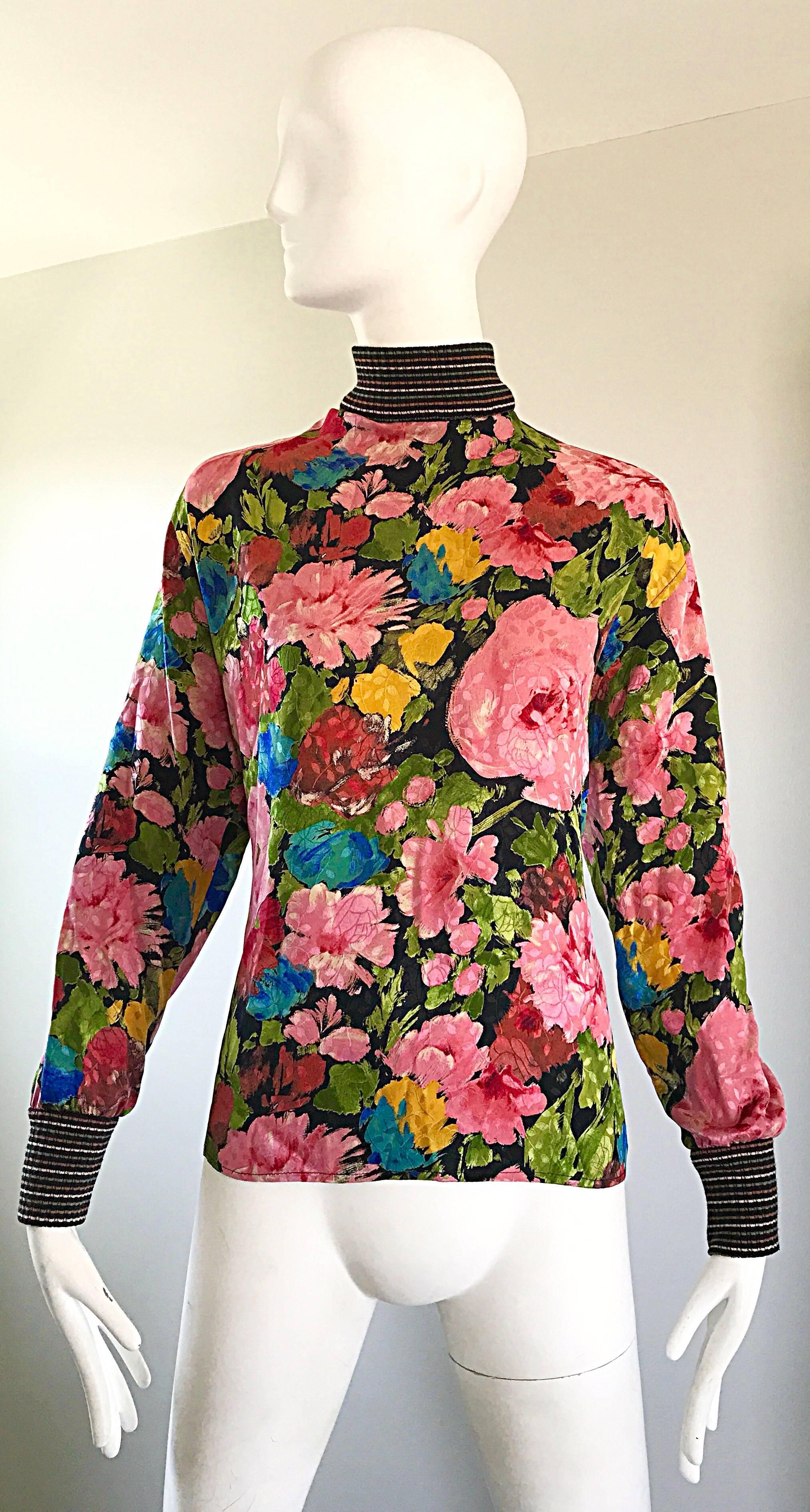 Beautiful 1990s EMANUEL UNGARO floral print silk and knit blouse! Features vibrant colored flowers in pink, blue, green, and yellow throughout. Luxurious silk body with fitted striped knit sleeve cuffs and collar. Black lacquer buttons up the back.