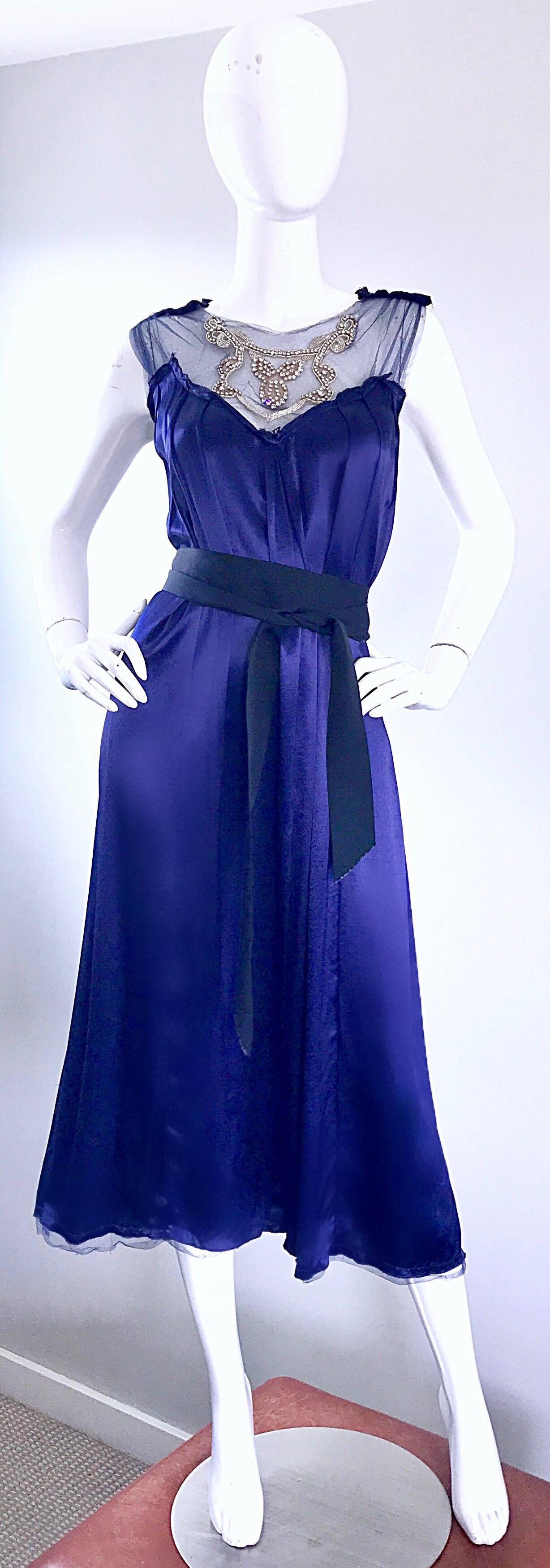 Gorgeous mid 1990s TRELISE COOPER navy blue 'liquid' silk belted midi dress! This beauty is so flattering and forgiving! Features hundreds of hand-sewn rhinestones on the mesh bodice. Detachable black silk grosgrain ribbon belt ties around twice, or
