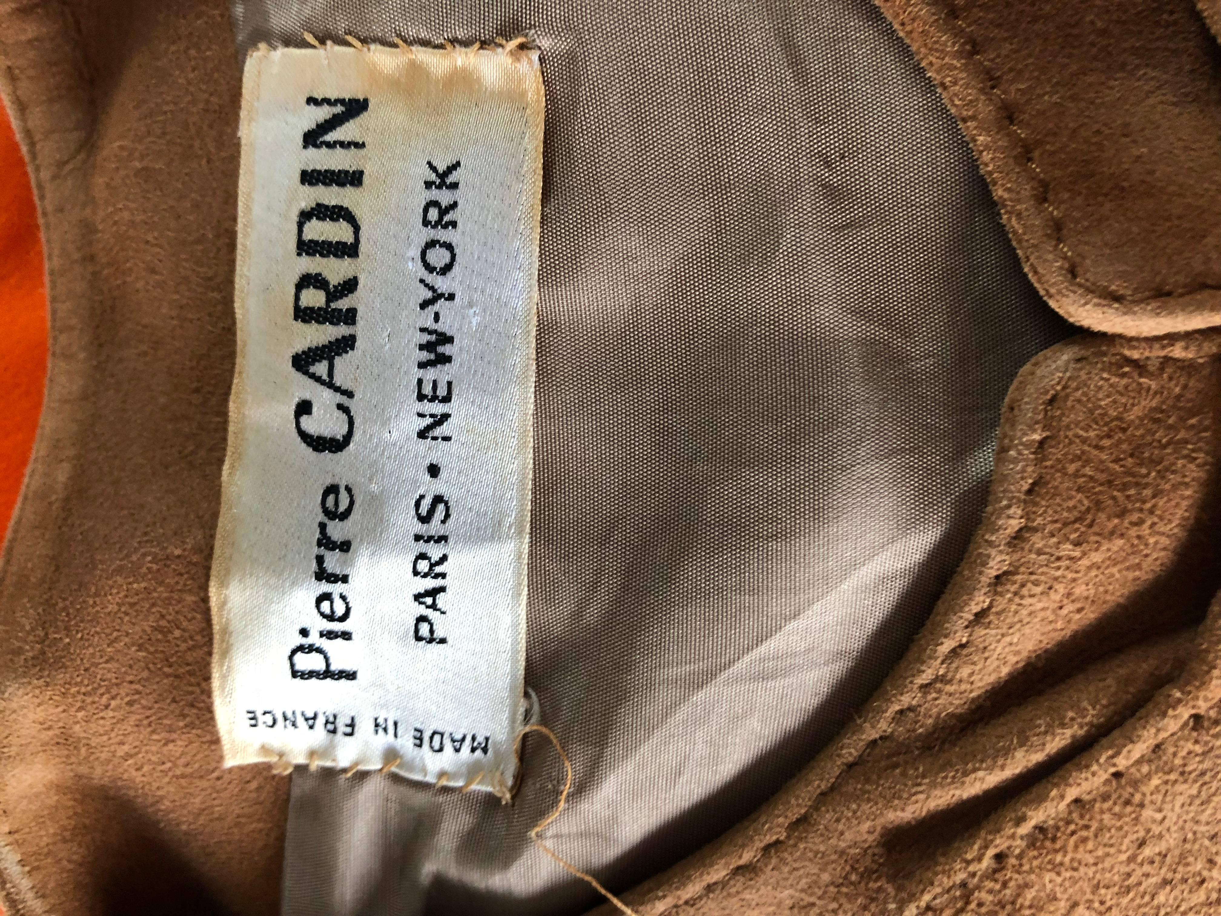 Iconic Avant Garde late 1960s PIERRE CARDIN suede leather vest top! Features gold plated buckles up the front. Soft suede leather in a beautiful tan color that literally matches everything. Fantastic tailored fit. Fully lined. 
Great alone with