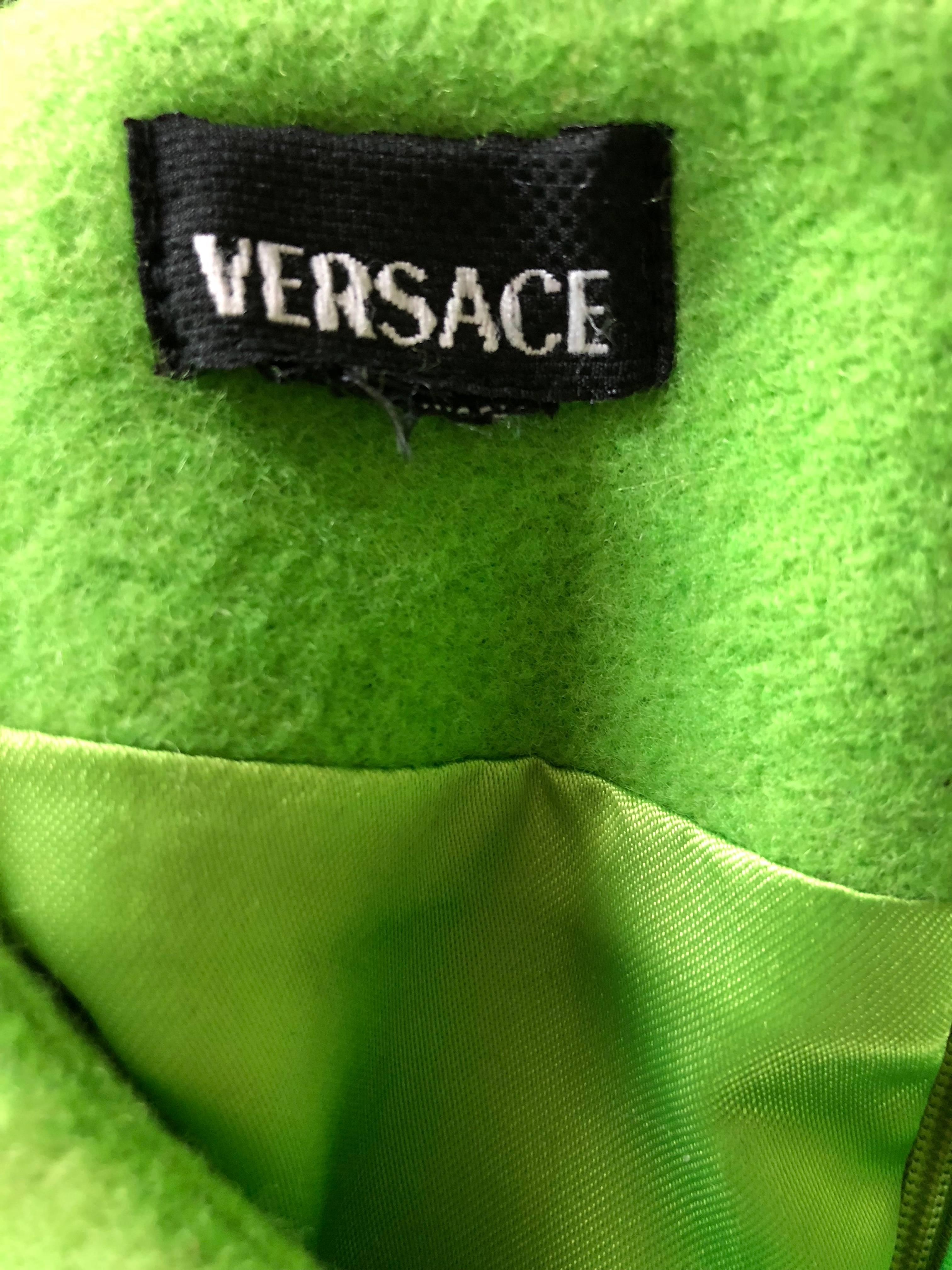 Incredibile mini abito in lana verde neon di GIANNI VERSACE dei primi anni '90! È caratterizzato da morbida lana vergine, con sfere di metallo dorato a forma di triangolo sopra il busto. Cerniera nascosta sul retro con chiusura a gancio. Vestibilità