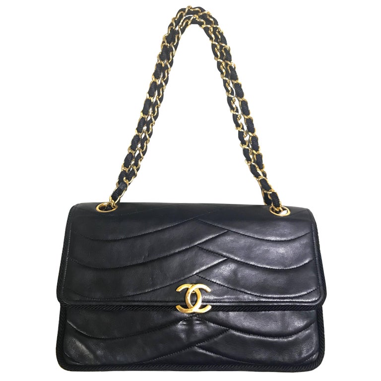 Chanel Vintage black 2.55 shoulder bag with wavy stitches and rope strings.