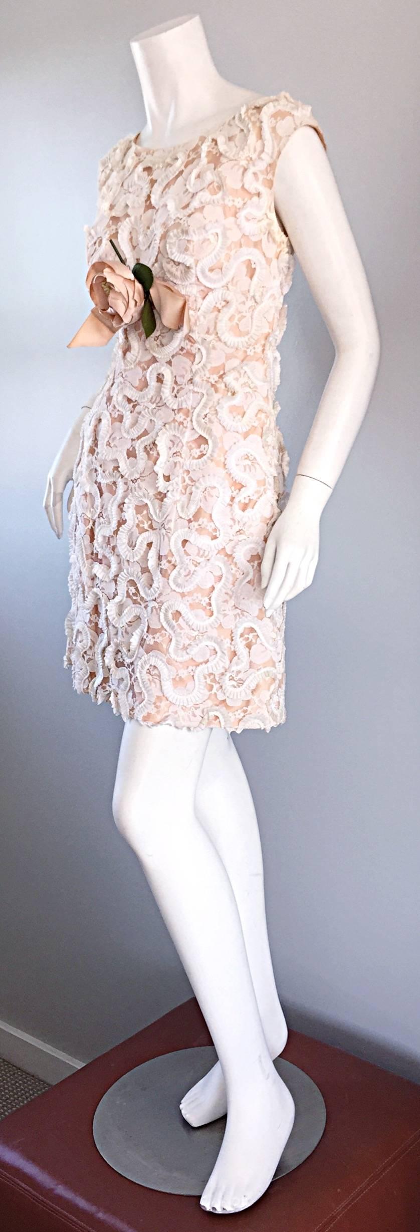 Cutest 1960s vintage A-Line mini dress! Intricate lace detail throughout, with pink silk bow at waist, with a removable flower corsage. Looks amazing on! Fully lined. Looks great with sandals, wedges or heels. Full metal zipper up the back. In great