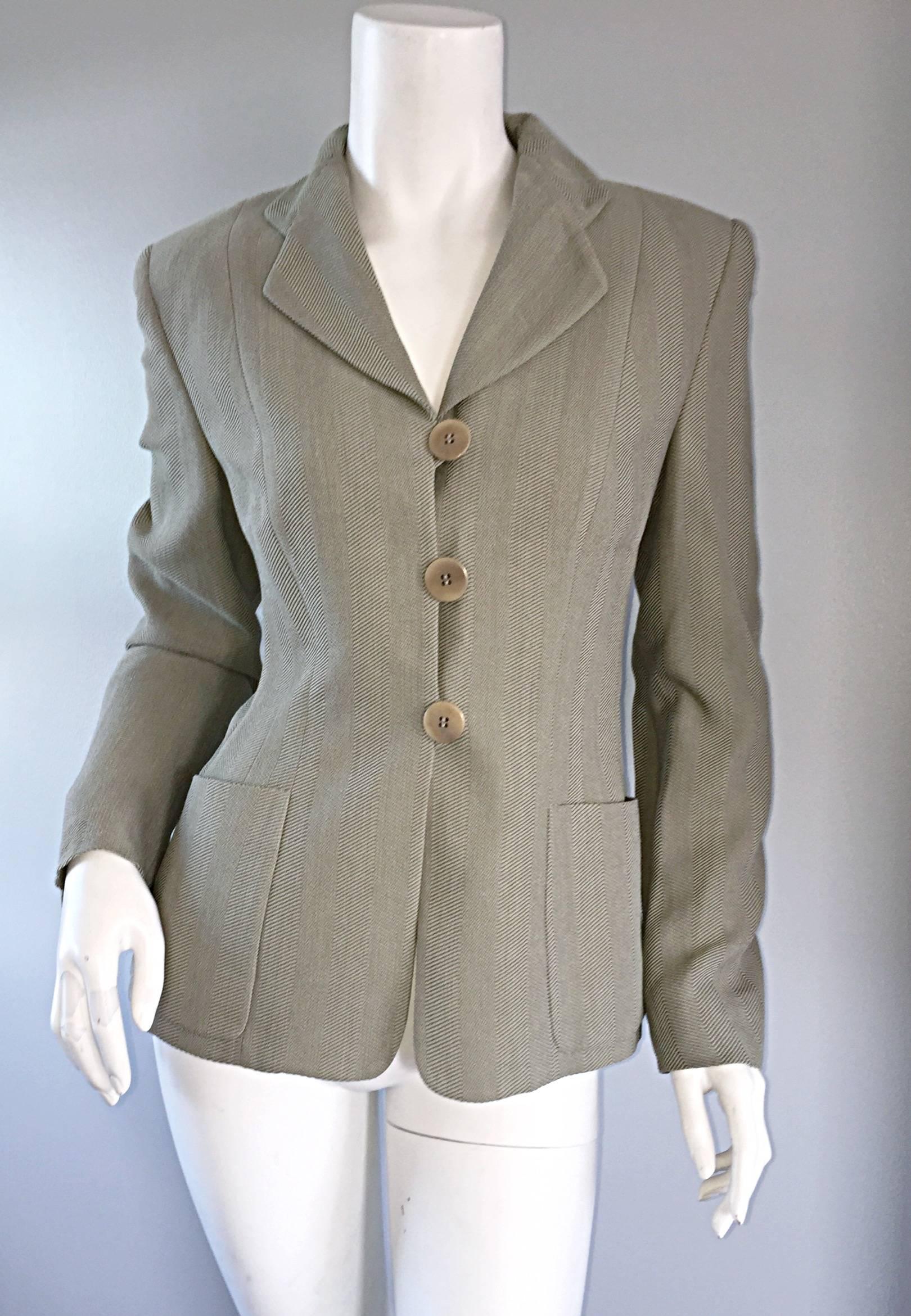 Blazer vintage Giorgio Armani magnifiquement taillé ! Ce blazer ajusté est de couleur kaki/à la limite du vert clair, avec un imprimé à chevrons sur toute la surface. Deux poches de chaque côté de la taille. Trois boutons sur le corsage. Peut