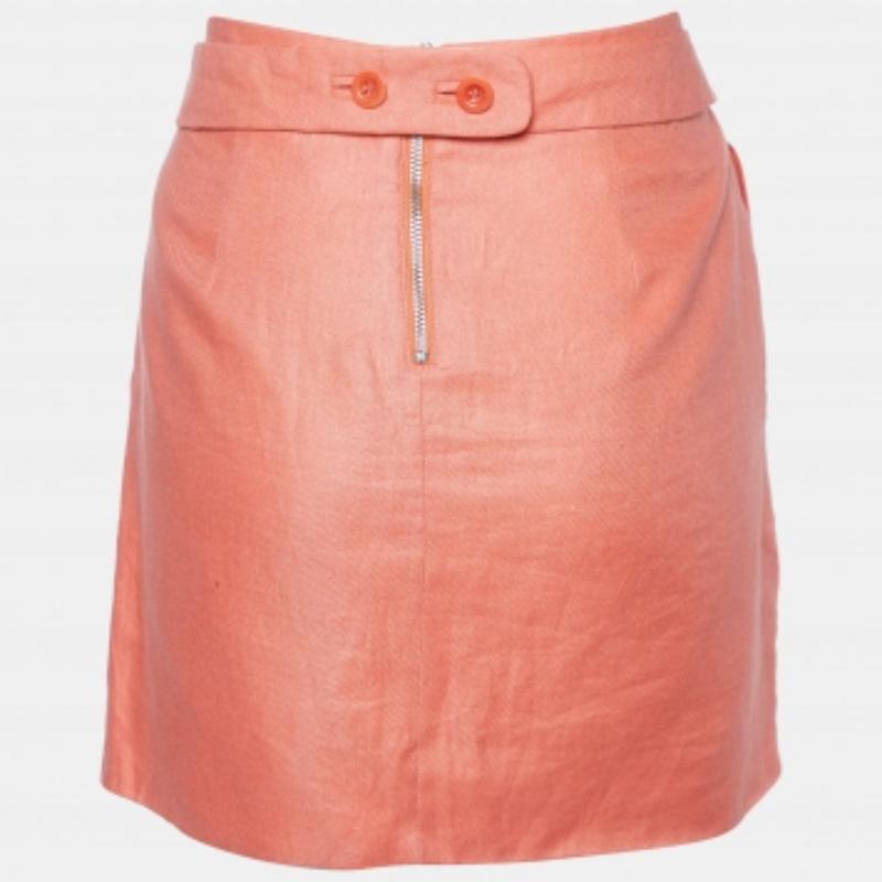 Cattura l'essenza dell'eleganza estiva con la gonna See by Chloé. Realizzata in lino leggero, questa gonna vanta un'elegante silhouette ad A, ornata da delicate pieghe per un tocco di femminilità. La morbida tonalità corallo aggiunge un fascino