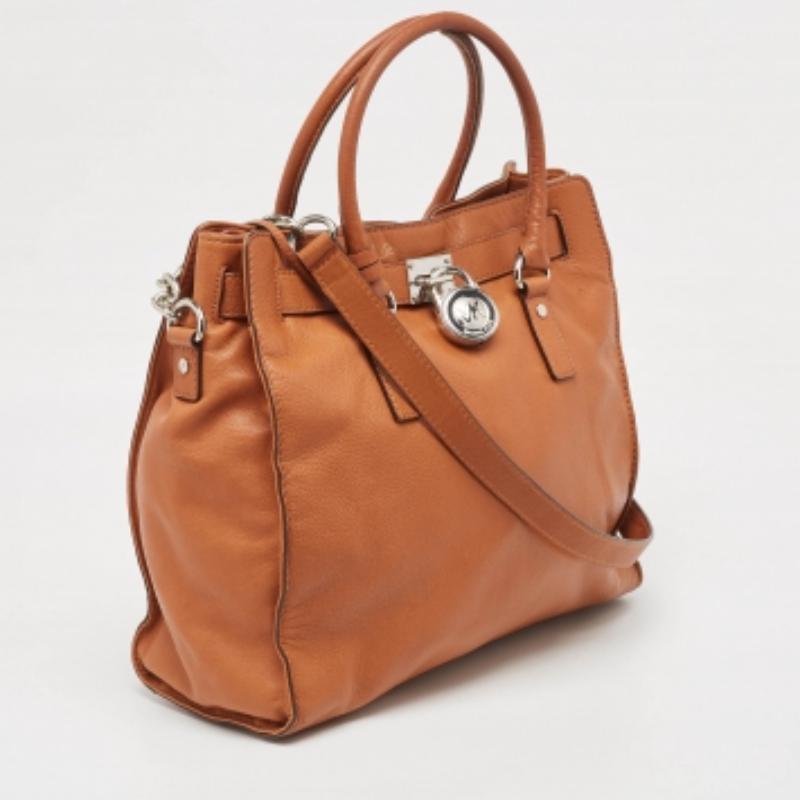 Assicurati che gli elementi essenziali della tua giornata siano in ordine e che il tuo outfit sia completo con questa tote di MK. Realizzata con i migliori materiali, la borsa porta la firma della maison di artigianato artistico e fascino duraturo.