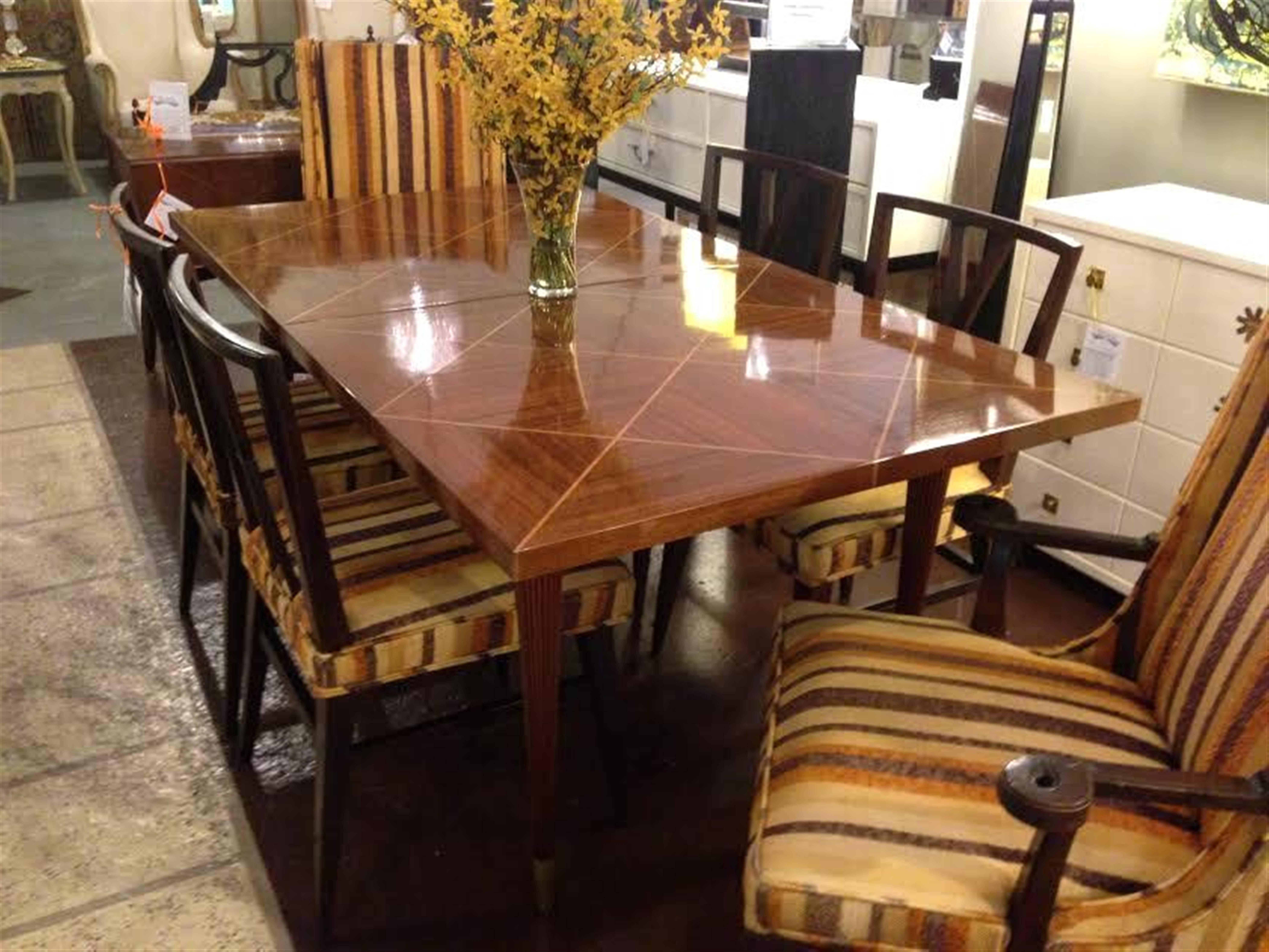 Tommi Parzinger dining table with two leaves by Charak. Beautiful Tommi Parzinger for Charak extension dining table in flamed mahogany with a parquetry inlaid top and fluted brass capped legs. With two 17
