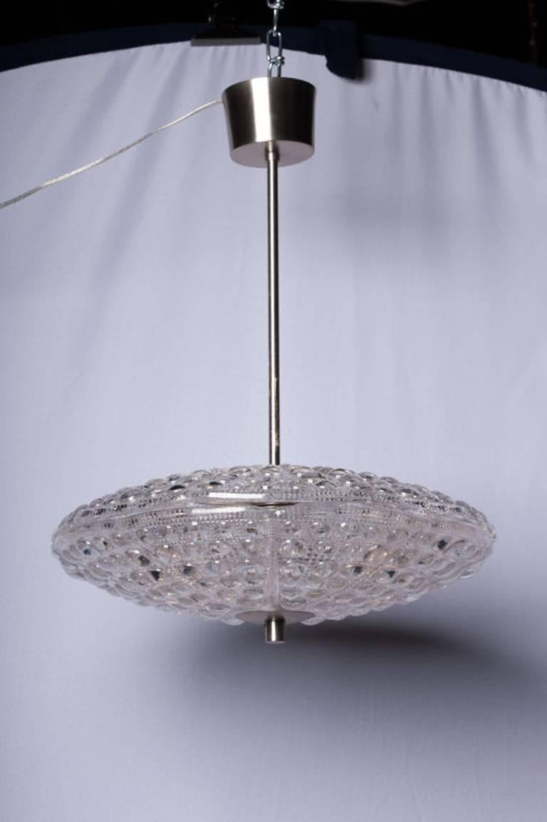 Dual crystal disc chandelier with a raised dot pattern on a satin nickel stem and canopy by Carl Fagerlund for Orrefors.