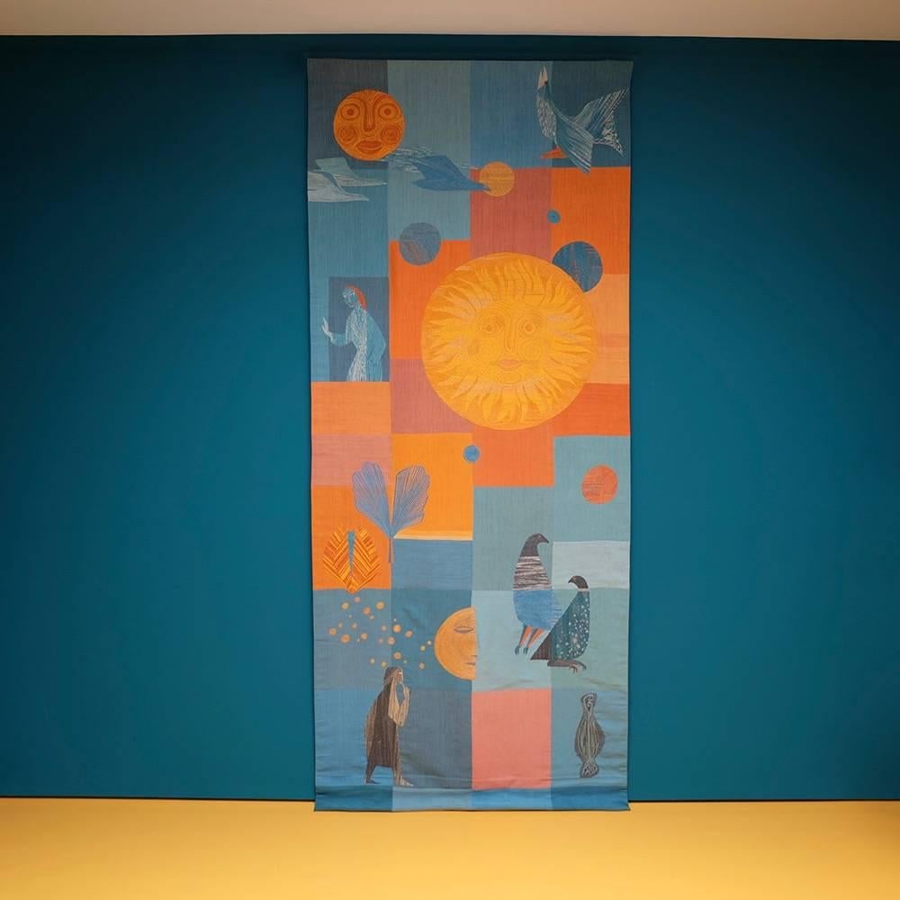 Unusual silk tapestry depicting the sun, birds, people and abstract shapes. The artful use of vivid oranges and yellows combined with indigo differ from the usual palette of the 1950s.