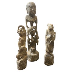 Trois statues de figures chinoises en bois patiné et pierre du milieu du 20e siècle
