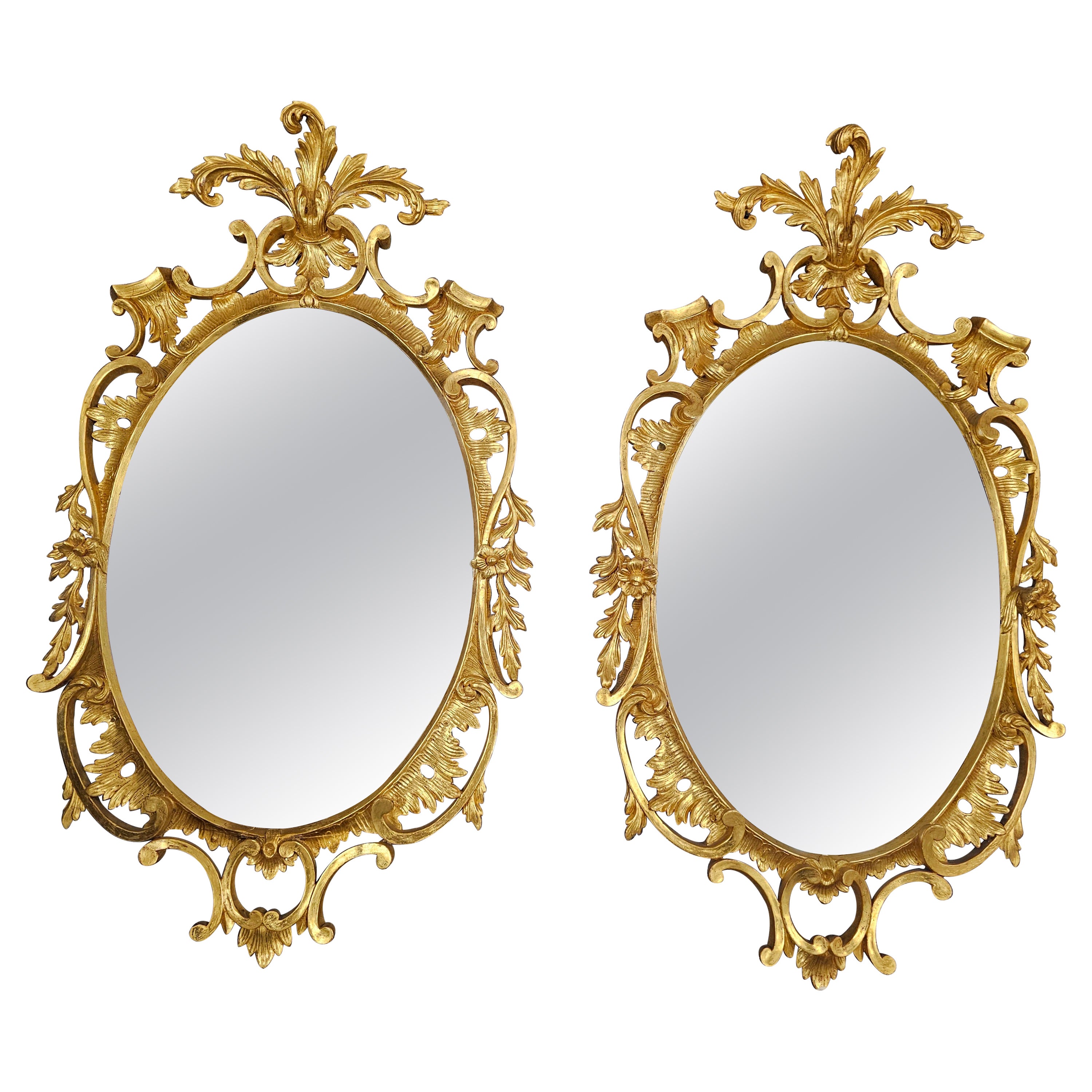 Paire de miroirs ovales à encadrement en bois sculpté et doré de style Louis XV du début du 20e siècle