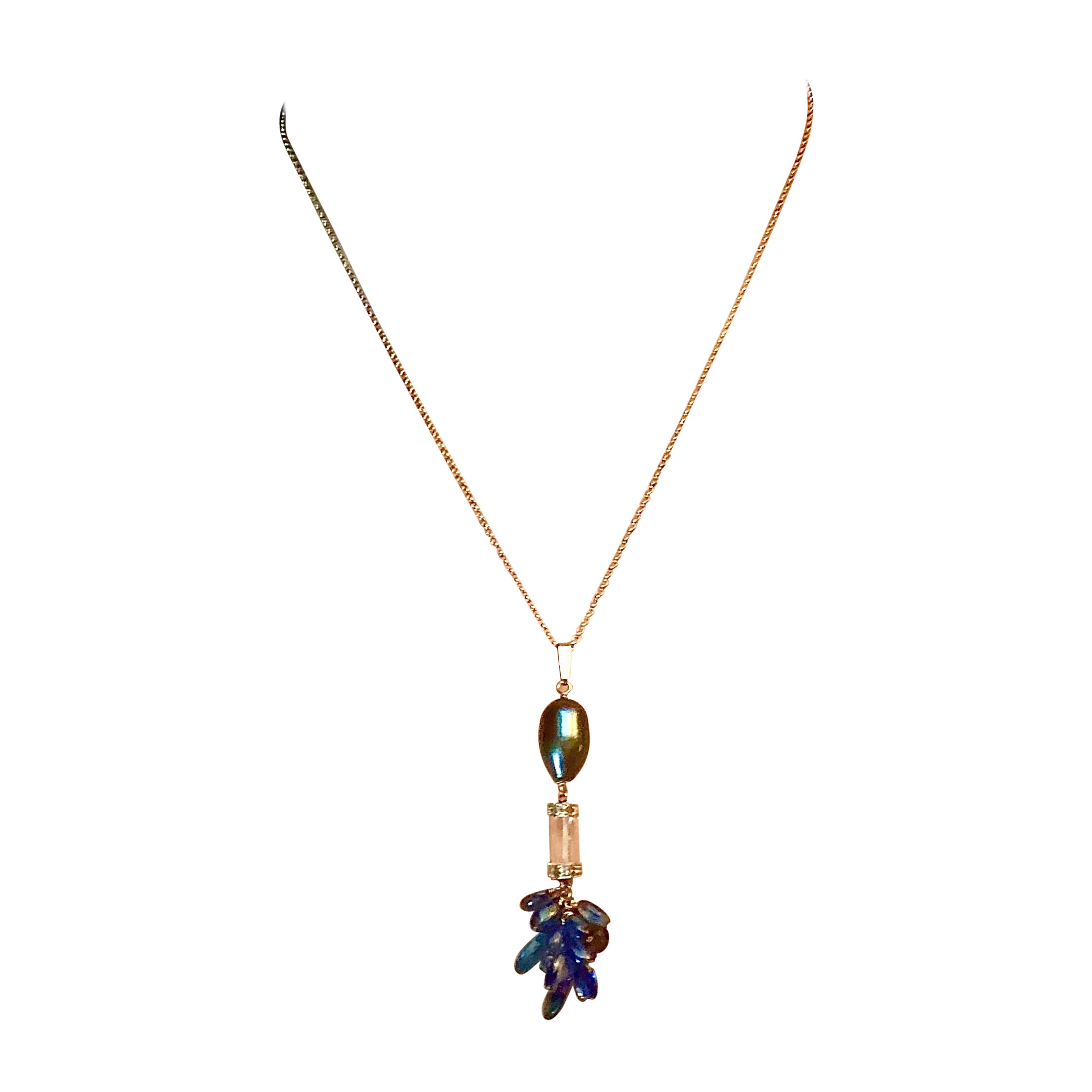 Black and green oval cultured/freshwater pearl pendant with faceted rock crystal tube bracketed with 14kt white gold diamond rondelles. Terminating in tassel of smooth teardrop stones of topaz, iolite and sapphires . Suspended on 14kt woven white