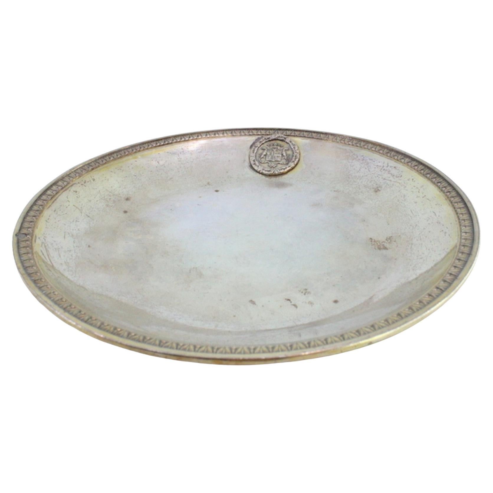 Bandeja de plata con friso en relieve en el borde y escudo de armas en el fondo liso