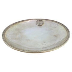 Plateau en argent avec frise en relief sur le bord et armoiries sur le fond lisse.