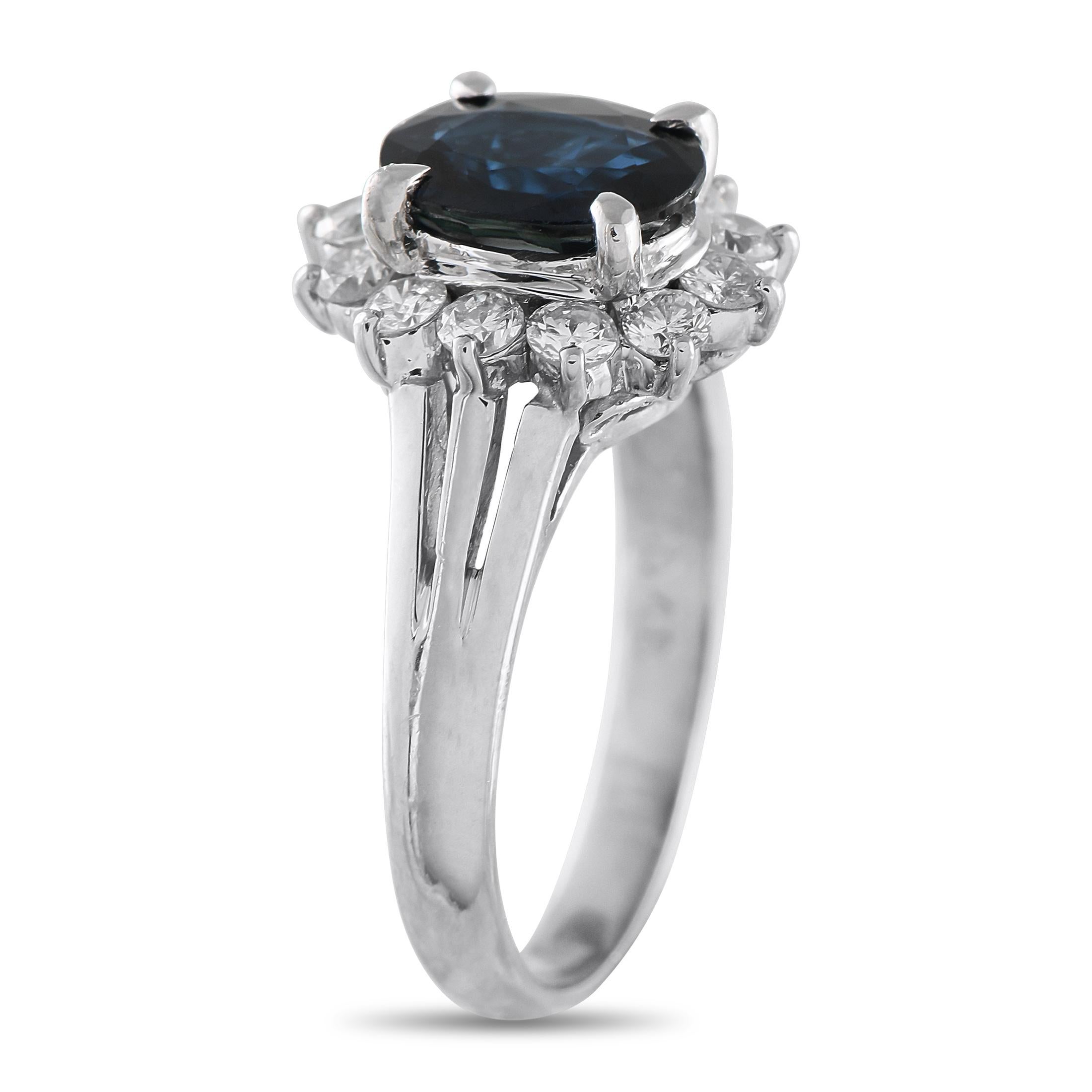 Uno zaffiro blu intenso è il protagonista di questo anello, circondato da un'aureola di diamanti brillanti. Il doppio gambo diviso dell'anello è finemente realizzato e appare come una leggera cresta che offre una dimensione sobria al design