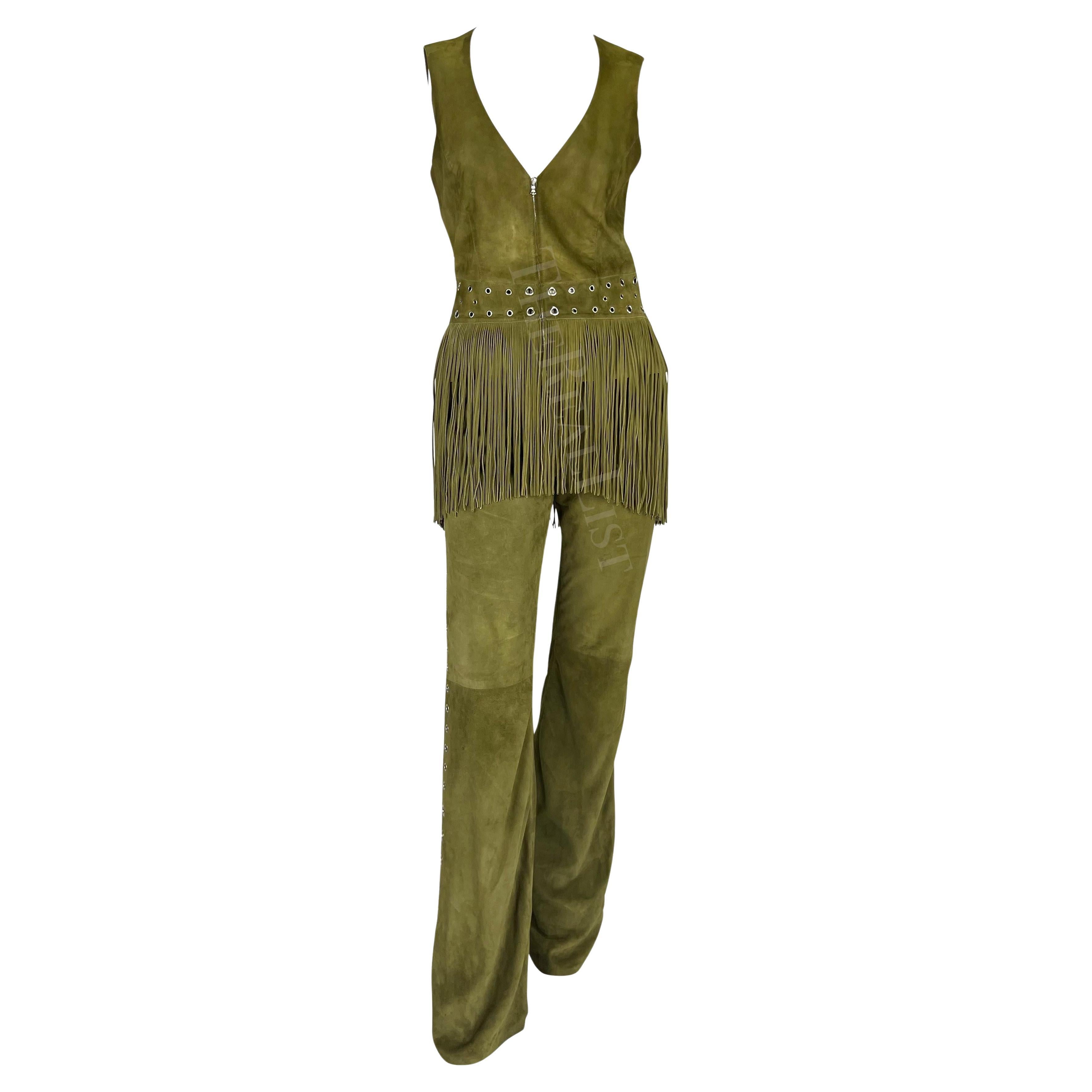 Ensemble veste et pantalon en daim vert olive de Thierry Mugler conçu par Manfred Mugler. Datant du début des années 2000, le pantalon et le gilet sont rehaussés d'œillets en métal argenté. Le pantalon présente une coupe évasée avec des œillets sur