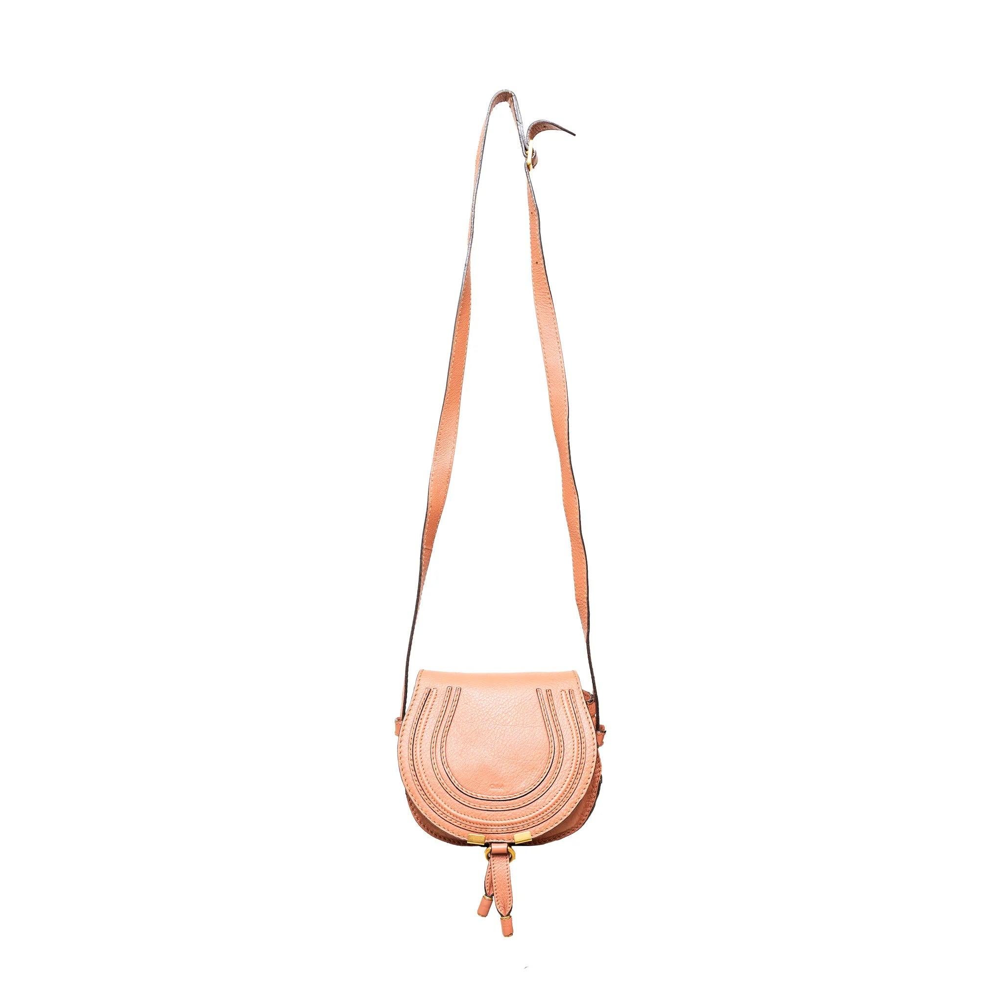 Questa mini borsa da sella Marcie, realizzata in pelle di vitello, combina una linea superiore elegante e una forma curva, riflettendo un mix di fascino equestre e stile femminile. 
 Osservazioni: ci sono alcune pieghe.  
 Misure:
