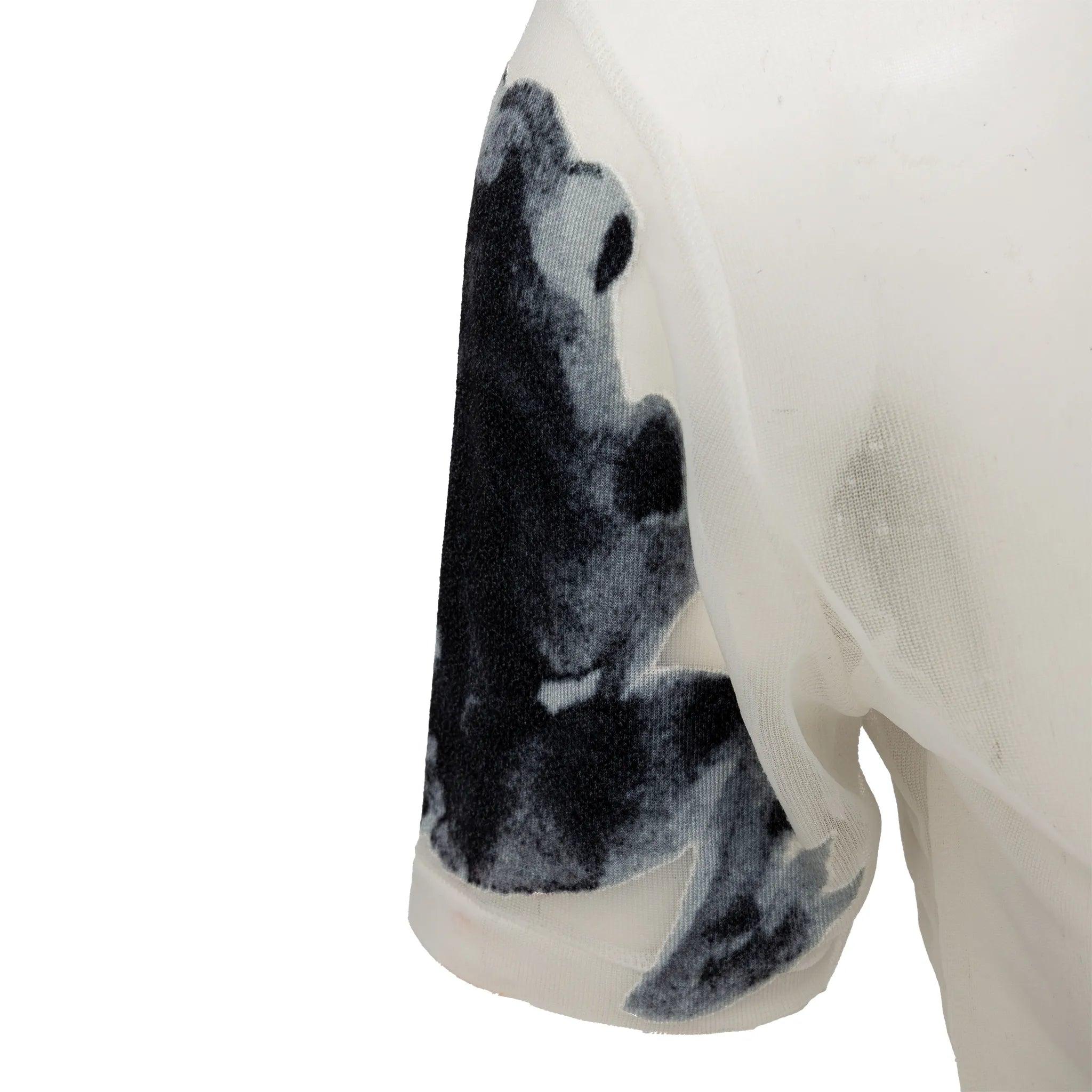 Issue de la collection printemps-été 2003 de Yohji Yamamoto. Top blanc transparent à col montant et manches courtes. Le délicat tissu en maille met en valeur les grenouilles gaufrées à l'aquarelle. 
 Remarques : Aucune étiquette n'est présente. Il y
