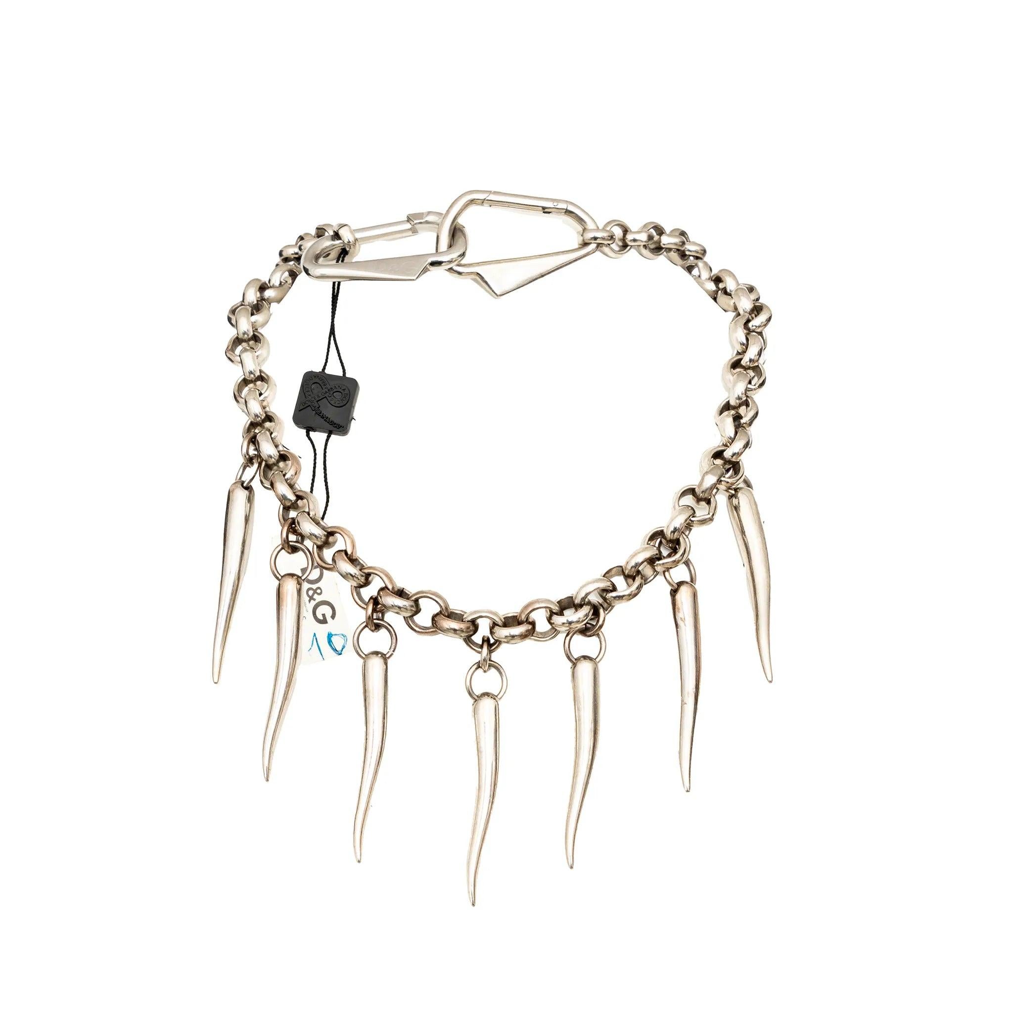 Il set di collane Fangs di Dolce & Gabbana in metallo argentato presenta 3 catene impilabili con zanne e dettagli del logo D.G.: indossale come collane a strati, girocollo o come cintura audace.  
 Misure: Lunghezza: 28-34  
 Materiale: Metallo