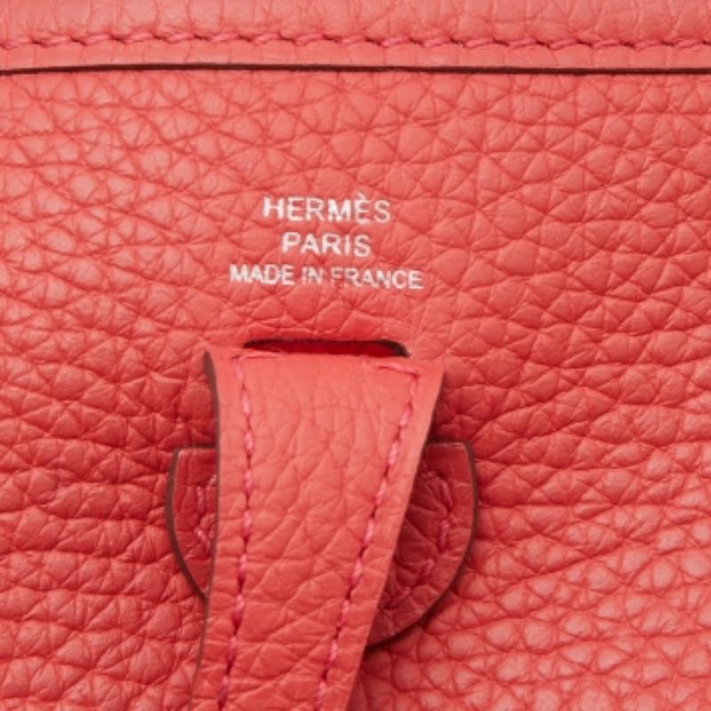 Die Evelyne ist eine weitere investitionswürdige Tasche von Hermès. Diese hier ist aus Taurillon Clemence Leder gefertigt und mit den charakteristischen Elementen der Lederlasche, der sattelförmigen Form und dem perforierten H auf der Vorderseite