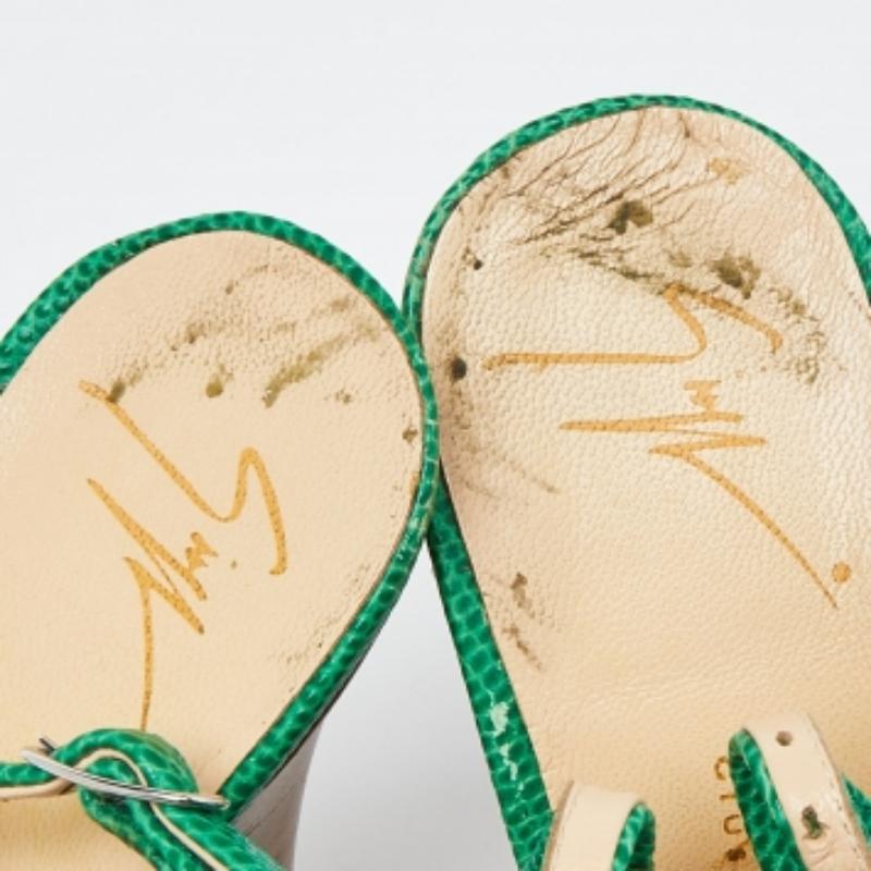 Une paire de sandales audacieuse et chic de Giuseppe Zanotti qui donne un coup de jeune à votre style. Confectionnées en cuir gaufré au lézard vert, ces sandales présentent des peep toes, des plates-formes dissimulées et des brides à boucle. Elles