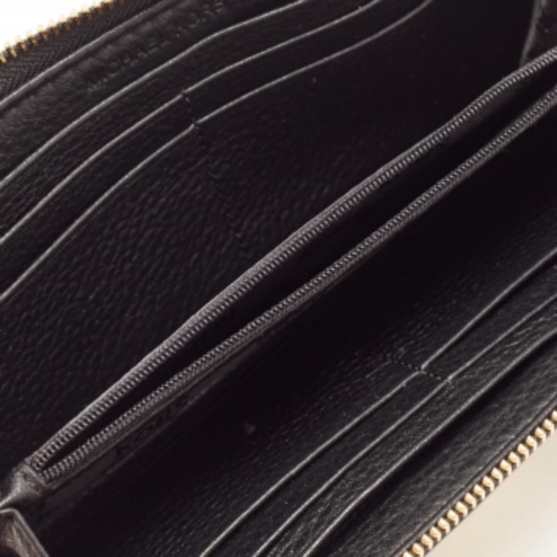 Funcionales y elegantes, las colecciones de Michael Michael Kors captan la delicadeza desenfadada y sin esfuerzo de la mujer moderna. Fabricada en piel de color negro, esta elegante cartera Jet Set tiene un interior compartimentado y se cierra con