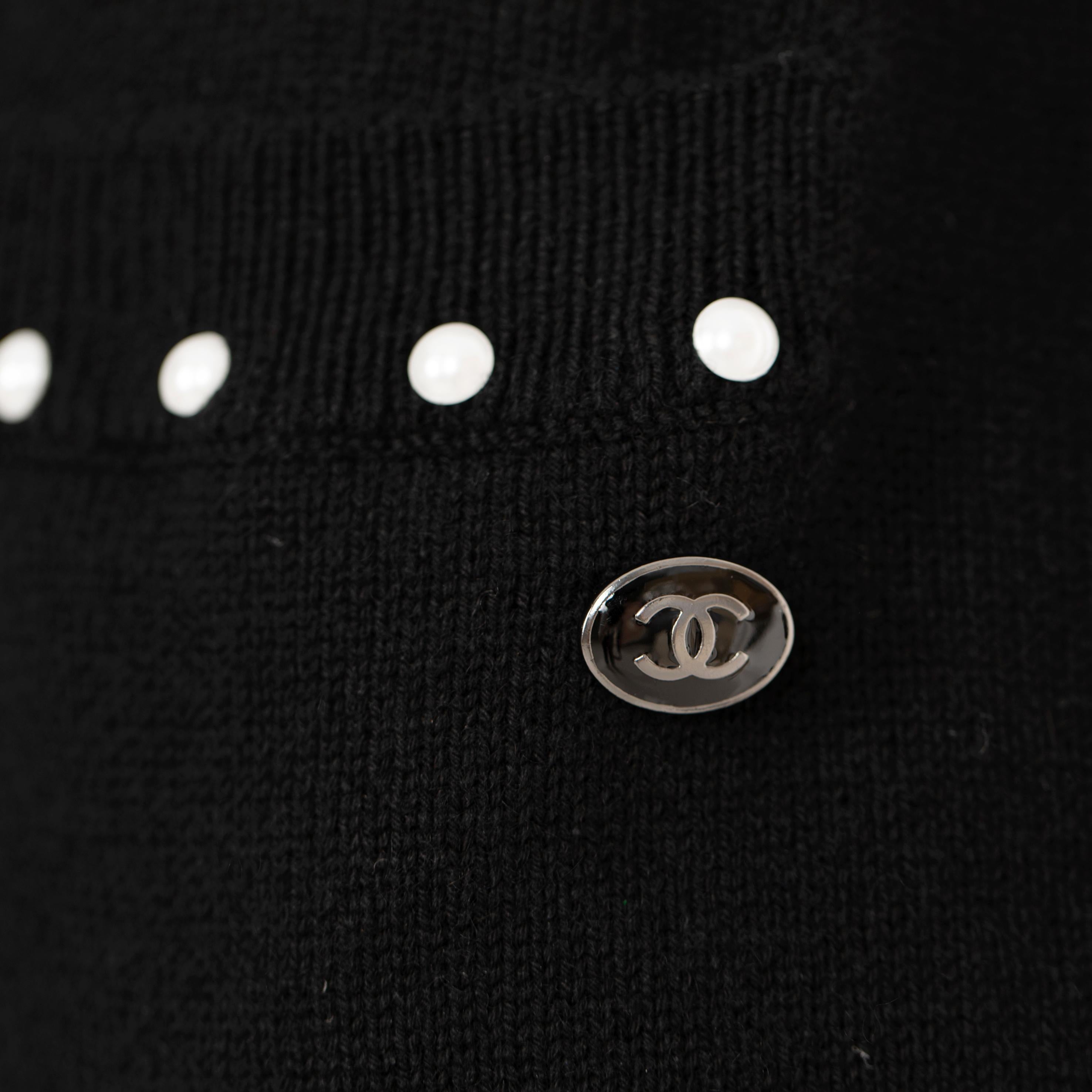 Cette robe intemporelle en maille noire de Chanel est parfaite pour être superposée en toute occasion. Les détails en fausses perles rehaussent le design pour un look sophistiqué. Confectionnée avec des matériaux de qualité, cette robe est sûre de