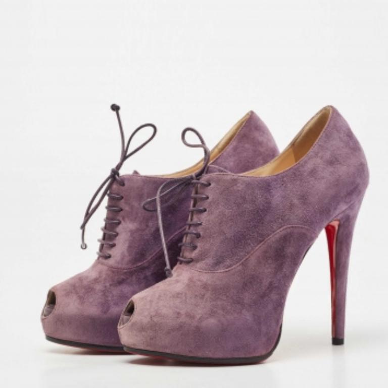 Sie sind aus hochwertigem lilafarbenem Wildleder gefertigt und haben eine Peep-Toe-Zehe sowie eine Schnürung. Mit ihrer schlanken Silhouette und der charakteristischen roten Sohle verleihen diese Christian Louboutin-Schuhe jedem Outfit einen Hauch