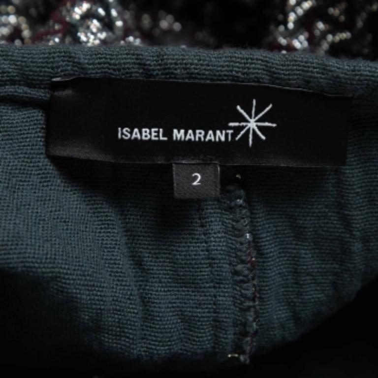 Ti presentiamo l'accattivante minigonna di Isabel Marant. Realizzato con precisione e stile, questo pezzo forte emana fascino e raffinatezza. La sua scintillante tonalità argentata, abbinata al tessuto di lusso, crea una Silhouette mozzafiato che