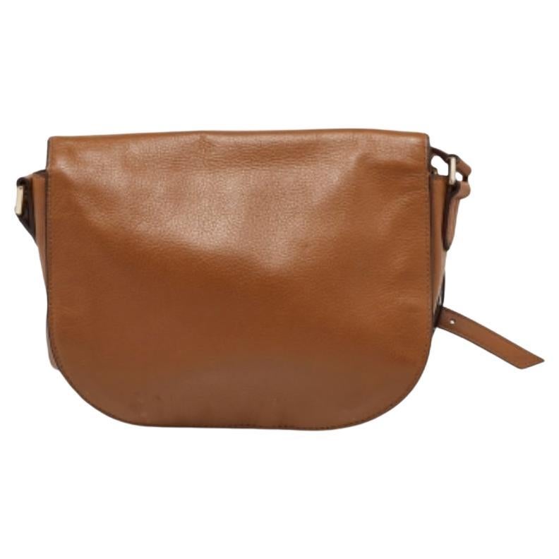 Questa borsa crossbody di Tory Burch è un'ottima opzione per trasportare i tuoi oggetti essenziali. Questa borsa in pelle marrone ha dimensioni compatte e una patta per proteggere l'interno foderato. Progettata per essere ideale per l'uso