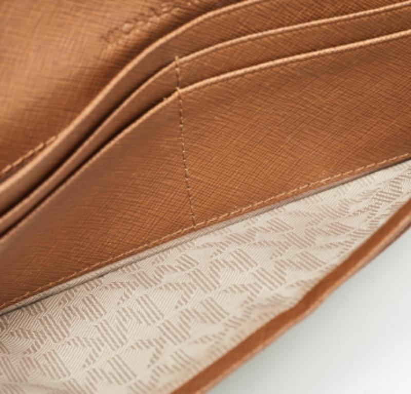 Assicurati che i tuoi oggetti essenziali siano al loro posto con questo portafoglio continentale di Michael Kors. Realizzato in pelle, il portafoglio marrone presenta il dettaglio del marchio sulla patta e un interno ben progettato per ospitare i