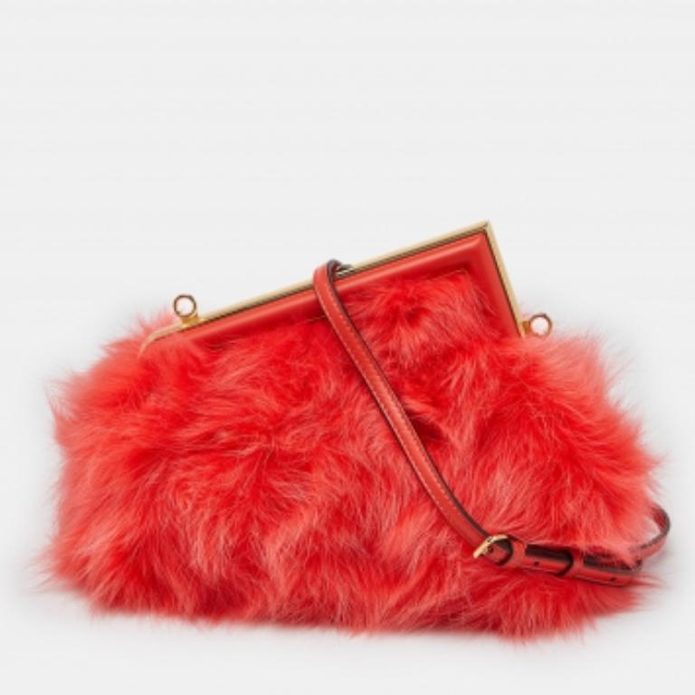 Invitez le charme mode de la pochette Fendi First dans votre garde-robe avec cette pièce que nous vous proposons ici. Il s'agit d'un sac First de petite taille en fourrure et en cuir, avec des ferrures dorées. Le logo F sur le dessus ressort