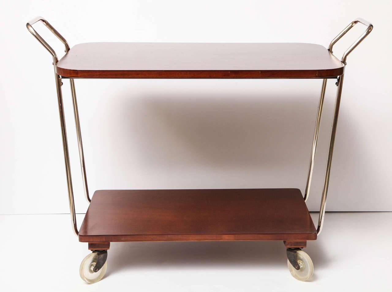 Mid-century modern bar cart, circa 1950. Wood with chrome details. The wood has been refinished and the chrome has been polished.