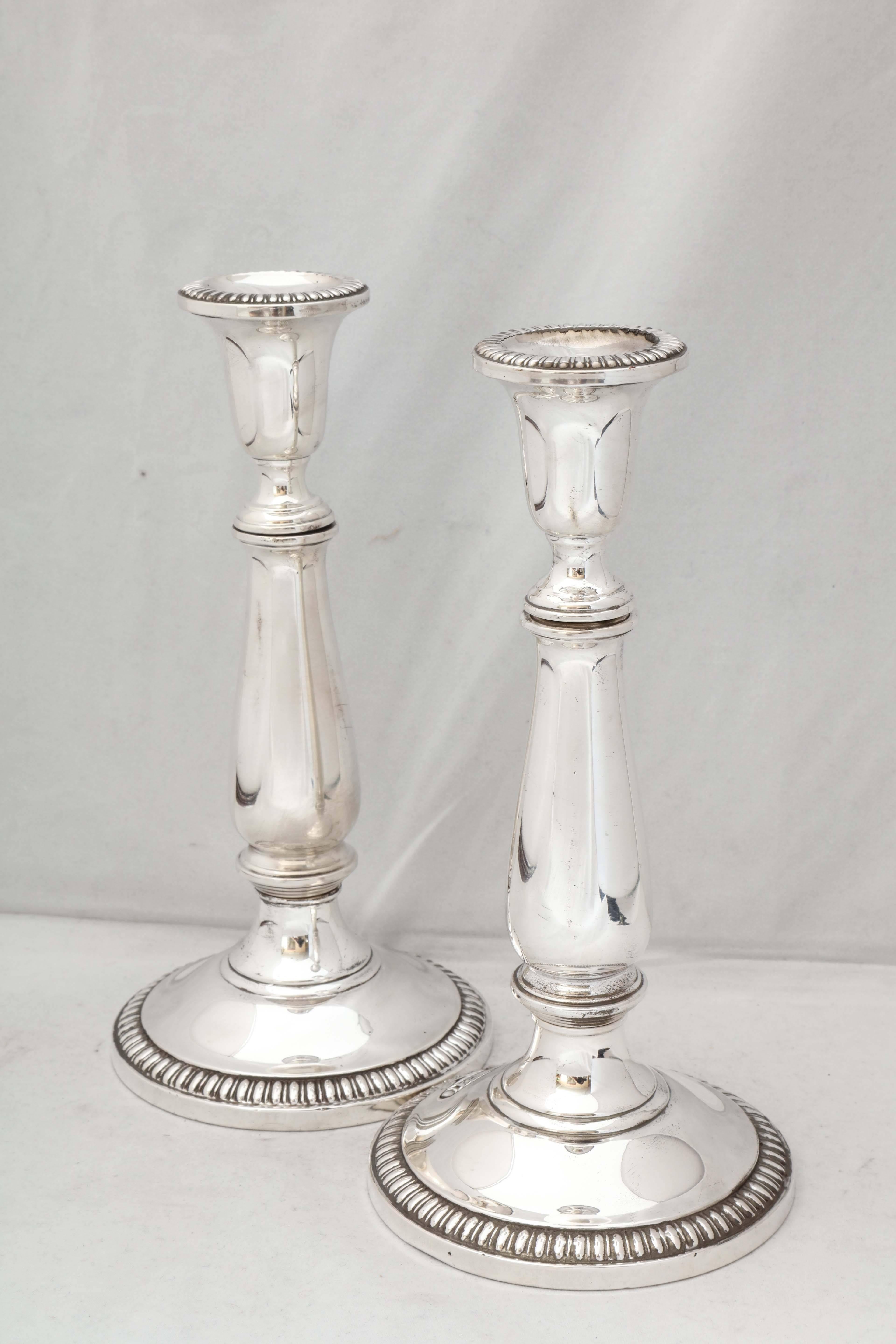Empire Style pair of sterling silver candlesticks, The Mueck-Carey Silver Co., New York, circa 1930's. Candlesticks separate into three pieces and can form two different sized candlesticks (see photos). Candlesticks have reeded borders on bases;