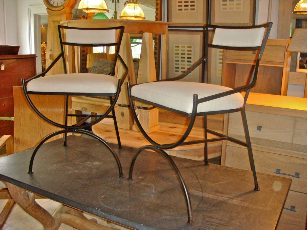 Wonderful pair of wrought iron chairs with new muslin upholstery.