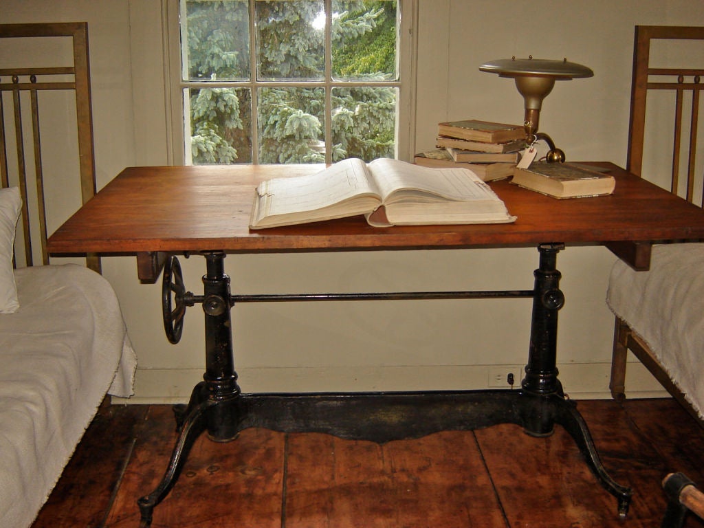Early 20th  century Iron drafting table by Dietzgen. One of their most elaborate tables and quite rare. Original top with metal clasps that make removal easy. Beautiful scrolled base would also make a great dining table base.