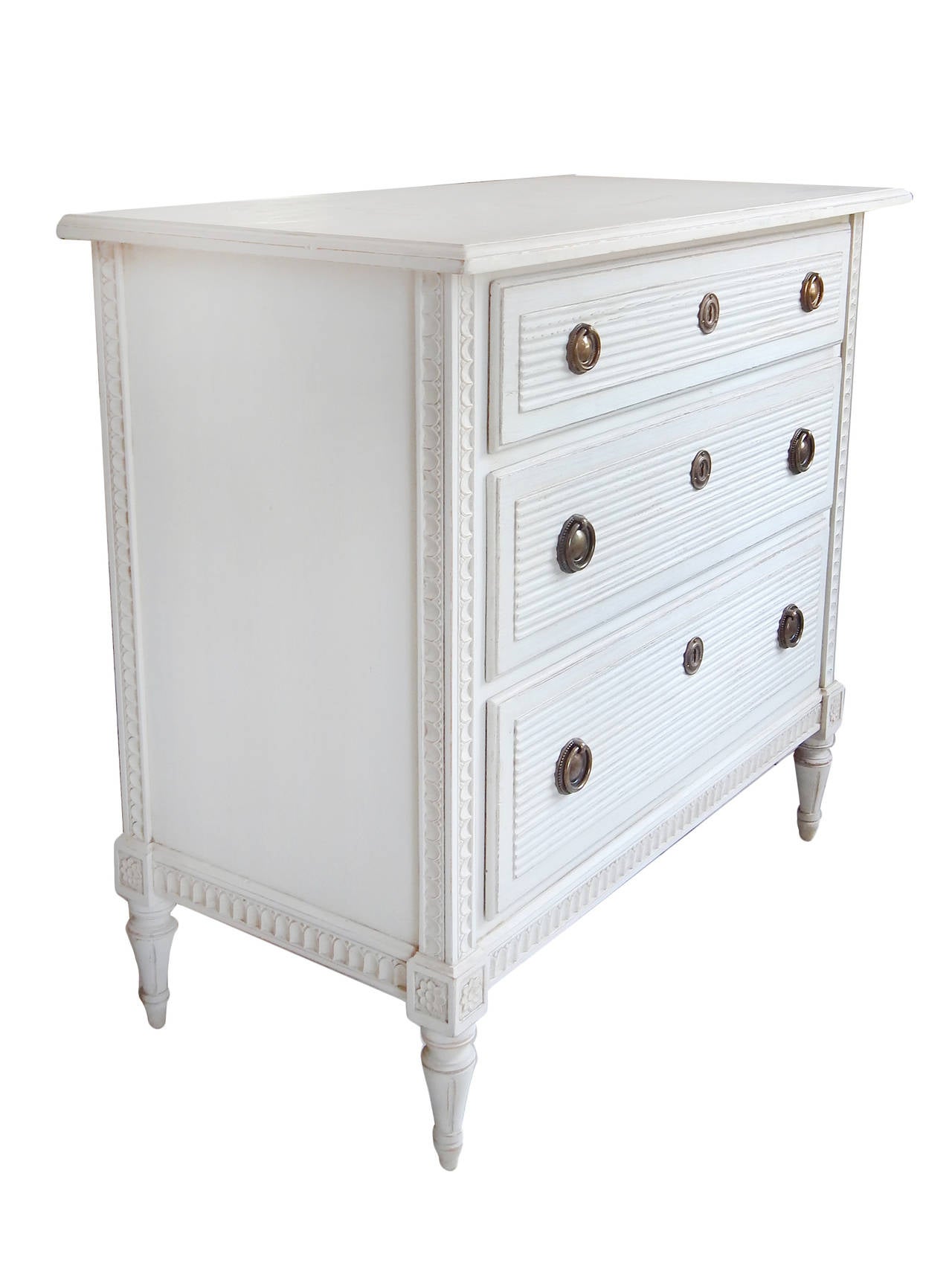 Delicately carved Swedish dresser in the Gustavian style, refinished in traditional off-white milk paint.