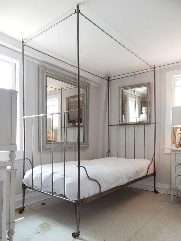 Great French iron twin bed with canopy rod on castors.