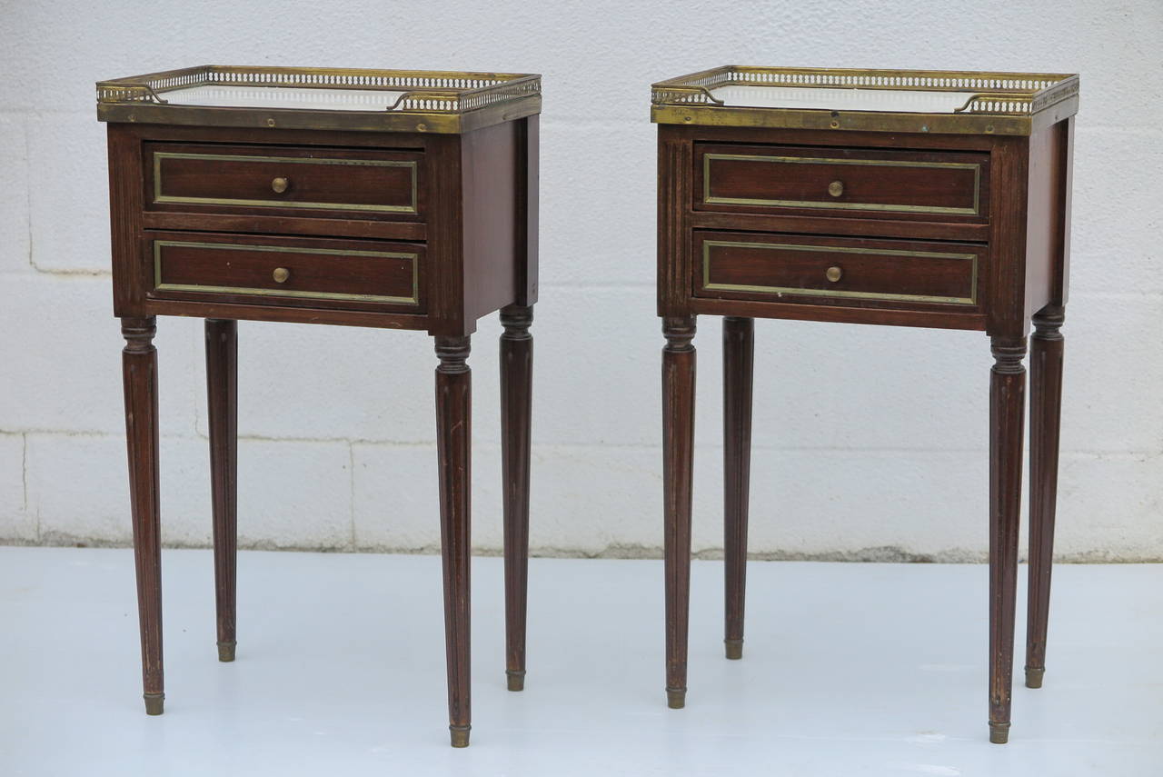 Smart pair of small directoire style night stands of side tables with 2 drawers with brass inlay detail, pierced brass gallery and original marble top c 1900
25.5